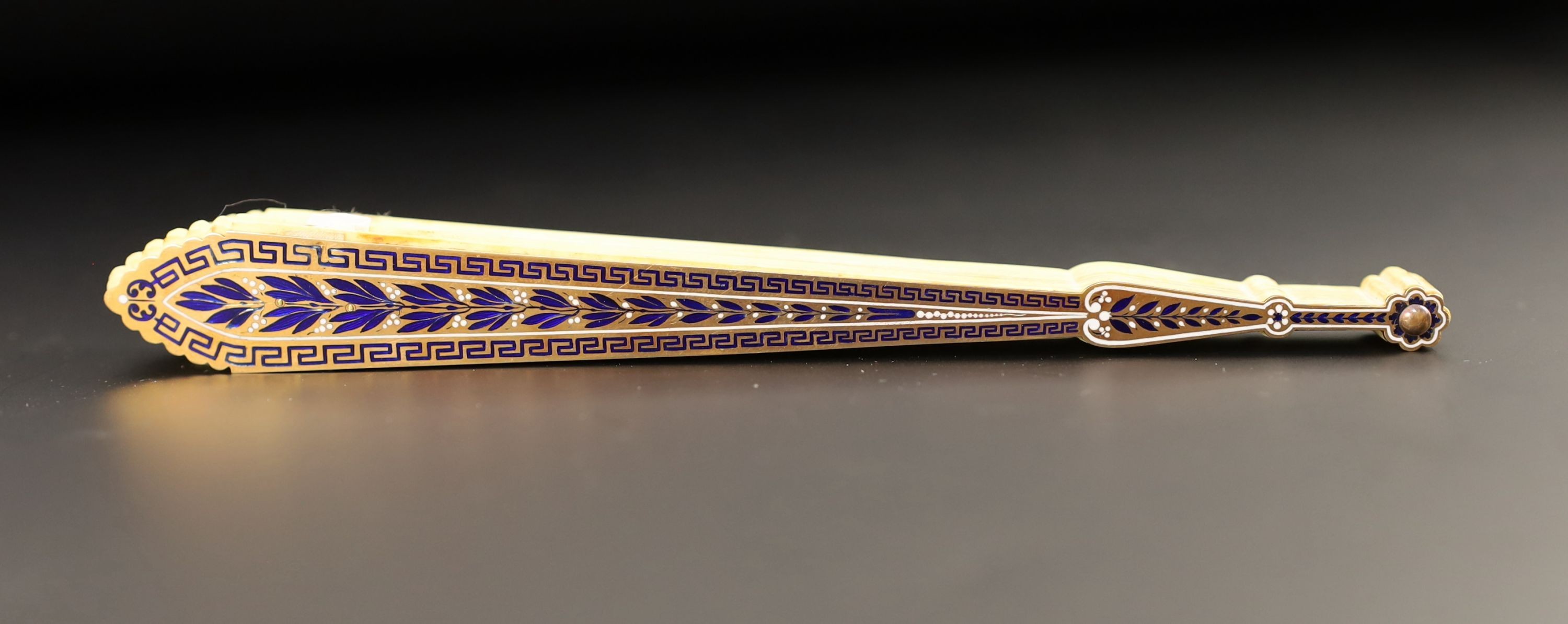 A German or Swiss gold, enamel and ivory brise fan, 19th century, possibly made for the Ottoman market, 17.3 cm closed, slight losses to sticks, needs rethreading
